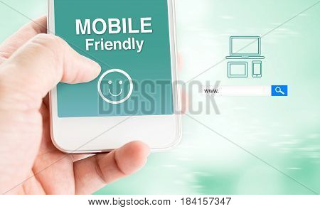 Hand Touch Mobile Phone With Mobile Friendly Word With Search Box At Blurred Blue Background, Digita