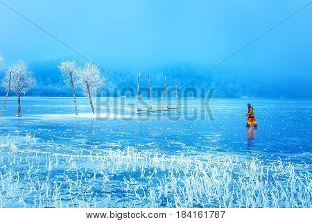 Woman on ice lake. Snowy landscape and snow covered trees and ice lake