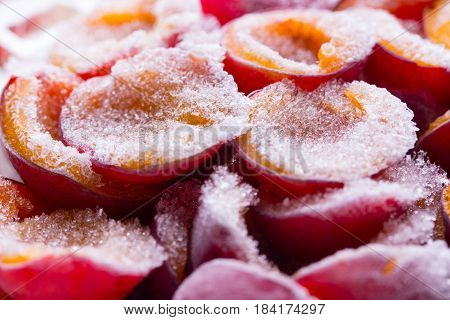 frozen half of a plum on a wooden background. Winter vitamins