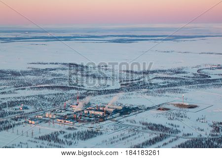 Oil and gas industry. Oil pump jack station in a oil field in tundra. Petrochemical object in West Siberia.