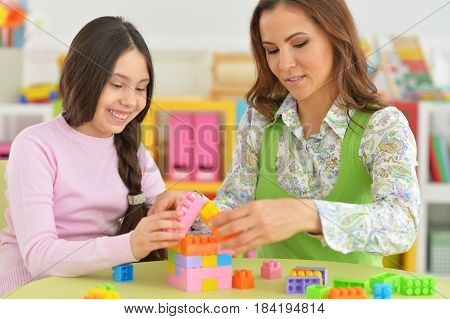 Mom and daughter have fun playing in the room