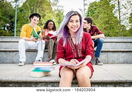 Multi-ethnic group of students stdying together outdoors in a college campus