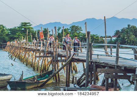Vietnam Nha Trang - April 10 2017: Old wooden bridgeAnd Vietnamese pioneers