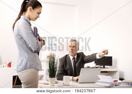 You are free now. Upset female bowing her head embracing documents while standing in semi position