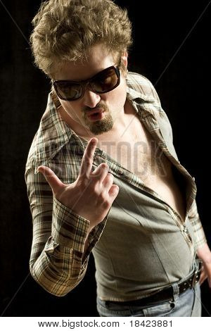 Hete mannelijk model poseren in strak shirt, jeans en zonnebril