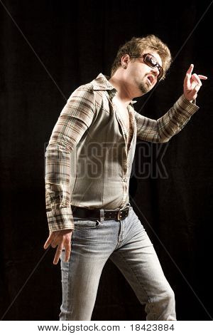Hete mannelijk model poseren in strak shirt, jeans en zonnebril