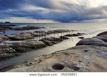 Long exposure of clouds and waves during sunset in Tip of Borneo, Sabah, Malaysia.