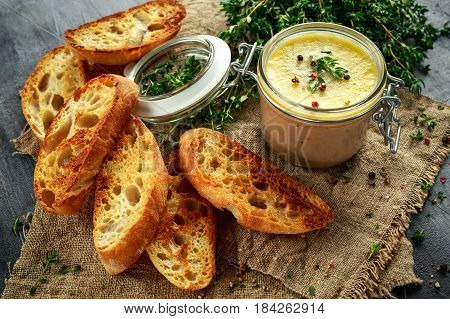 Home made chicken liver pate with thyme and ciabatta bread in jar.