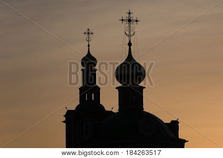 Photo of an Orthodox Christian cross on a background of gloomy clouds