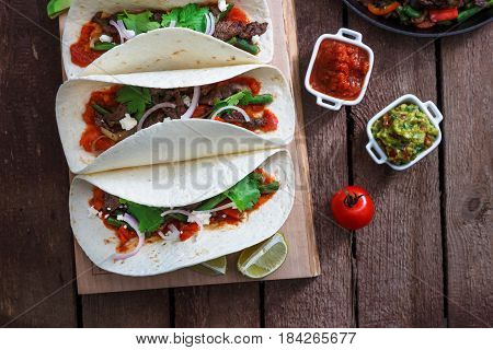 Above view of wheat wraps with mexican pork fajitas, selective focus, close view