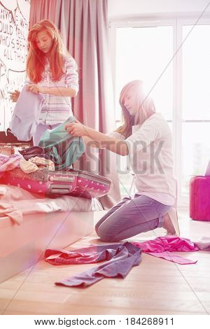 Sisters cleaning bedroom