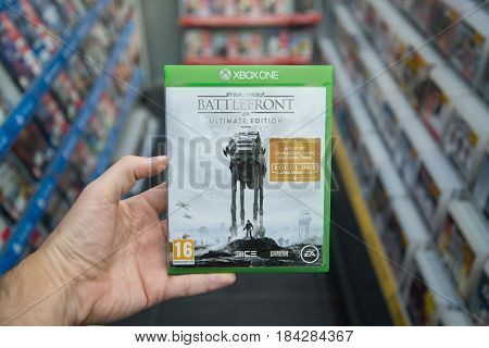 Bratislava, Slovakia, circa april 2017: Man holding Star Wars Battlefront Ultimate edition videogame on Microsoft XBOX One console in store