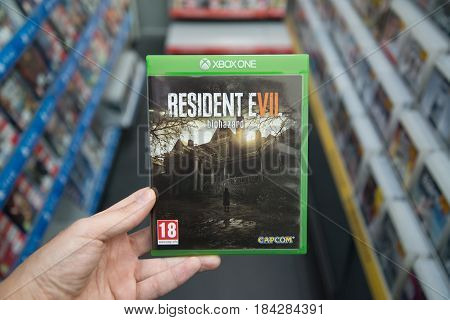 Bratislava, Slovakia, circa april 2017: Man holding Resident evil 7 videogame on Microsoft XBOX One console in store