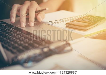 Businessman calculate cost and expenses using laptop for search data result.