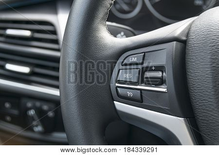 cruise control buttons on the steering wheel of a modern car car interior details