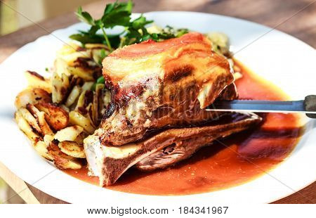 Traditional roasted pork Schaeufele Munich style with fried potatoes