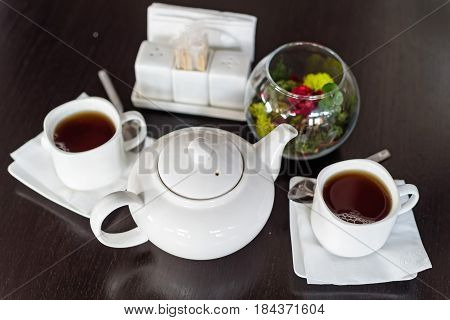 Teapot and cups are prepared for tea drinking in cafe