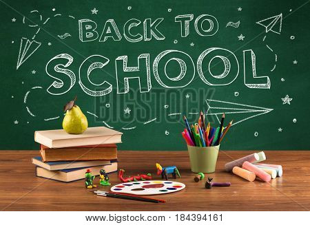Back to school concepty with writing on blackboard and desk, apple, books, items
