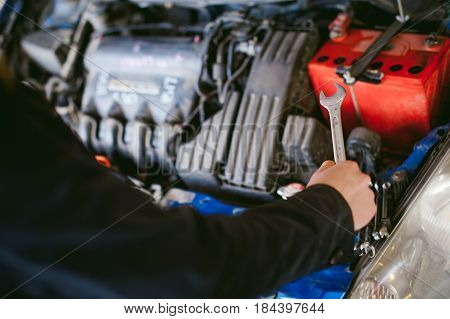 Woman Near Car's Hood. Young Blonde In Covered Parking Of Shopping Center, Stands Near Car With Engi