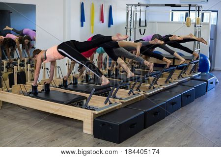 Group of women exercising on reformer in gym