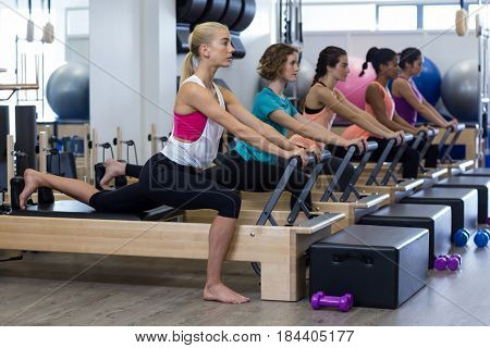Group of women exercising on reformer in gym