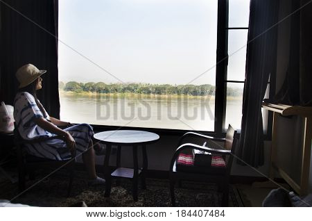 Alone Thai Woman Sitting On Chair Looking View Landscape And Flowing Of Mae Khong River