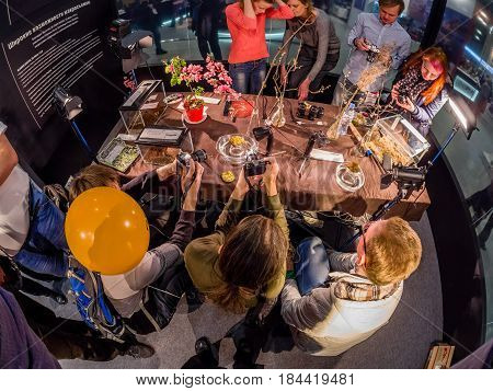 MOSCOW RUSSIA - APRIL 21 2017: Visitors take part in macro photography workshop at booth of Olympus company at PhotoForum 2017 trade show and exhibition in Moscow Russia on April 21 2017.