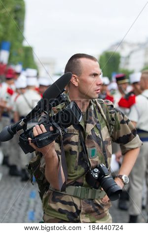 Paris. France. July 14 2012.Legionnaire photographer photographs parade on the Champs Elysees in Paris.
