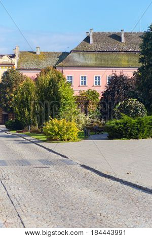 Traditional old town in Europe. Central square in Opatów, Poland with trees, cobbled street and old tenement house in pastel pink color.
Photo taken on: September 26th, 2014