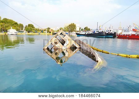 sunken boat reflected on water at Eleusis Greece