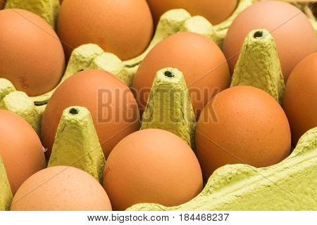 Freerange fresh raw eggs in recycled paper egg cartons or on the straw.