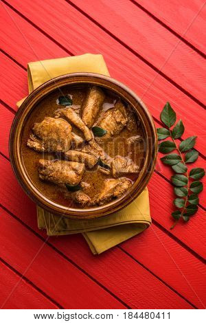 tasty fish curry served with white cooked basmati rice with curry leaves in the background, favourite coastal indian food