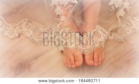 Tender feet girls look out from under a beautiful vintage lace dresses.