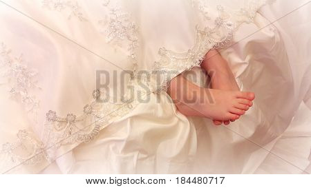 Tender feet girls look out from under a beautiful vintage lace dresses.