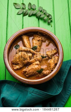 tasty fish curry served with white cooked basmati rice with curry leaves in the background, favourite coastal indian food