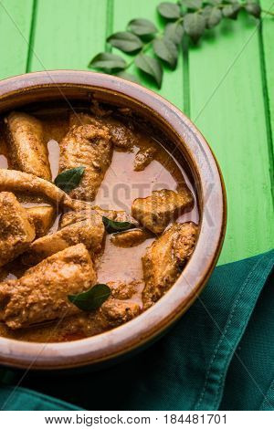 tasty fish curry served with white cooked basmati rice with curry leaves in the background, favourite coastal indian food