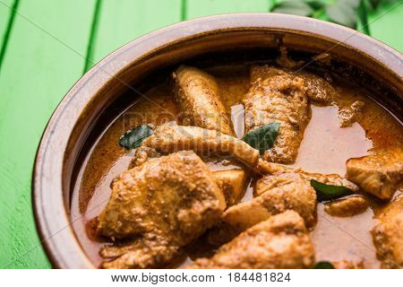 tasty fish curry served with white cooked basmati rice with curry leaves in the background, favourite coastal indian food