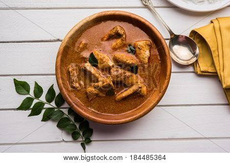 tasty fish curry served with white cooked basmati rice with curry leaves in the background, favourite coastal indian food