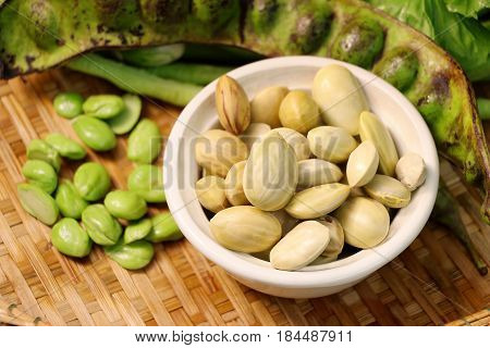 parkia speciosa seed or bitter bean twisted cluster bean or stink bean and Thai name is sataw or sator on bowl. Sato preserved