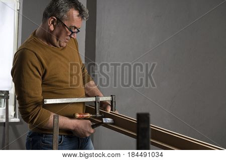 Carpenter Using Screw Clamp     