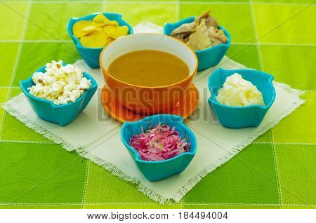 Special mixture of magenta bowls contain, onions, smashed yucca, poopcorn, fry plantains, albacore fish, ready to mix and prepare the encebollado.
