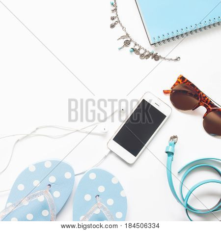 Flat lay of woman accessories in blue color collection with smartphone isolated on white background