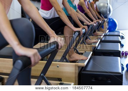 Group of women exercising on reformer in gym