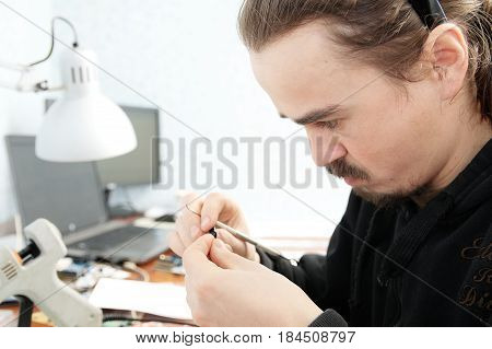 young man sculpting handmade miniature plastic toy house decoration craftsmanship hobby decor creation process