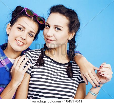 best friends teenage school girls together having fun, posing emotional on blue background, besties happy smiling, lifestyle people concept close up