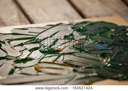 Palette with green color on wooden table