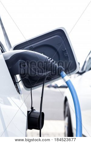 Electric vehicle pluged in at the charging station