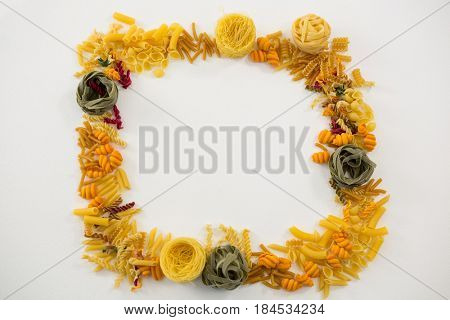 Varieties of pasta forming frame on white background