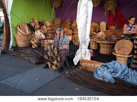 CAMACHA MADEIRA PORTUGAL - SEPTEMBER 10 2016: A basket weaver at work in the factory shop in Camacha Madeira Portugal