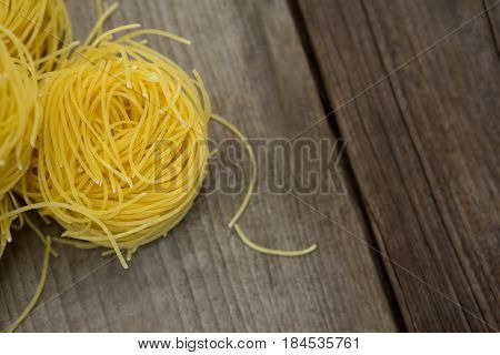 Close-up of capellini pasta on wooden surface